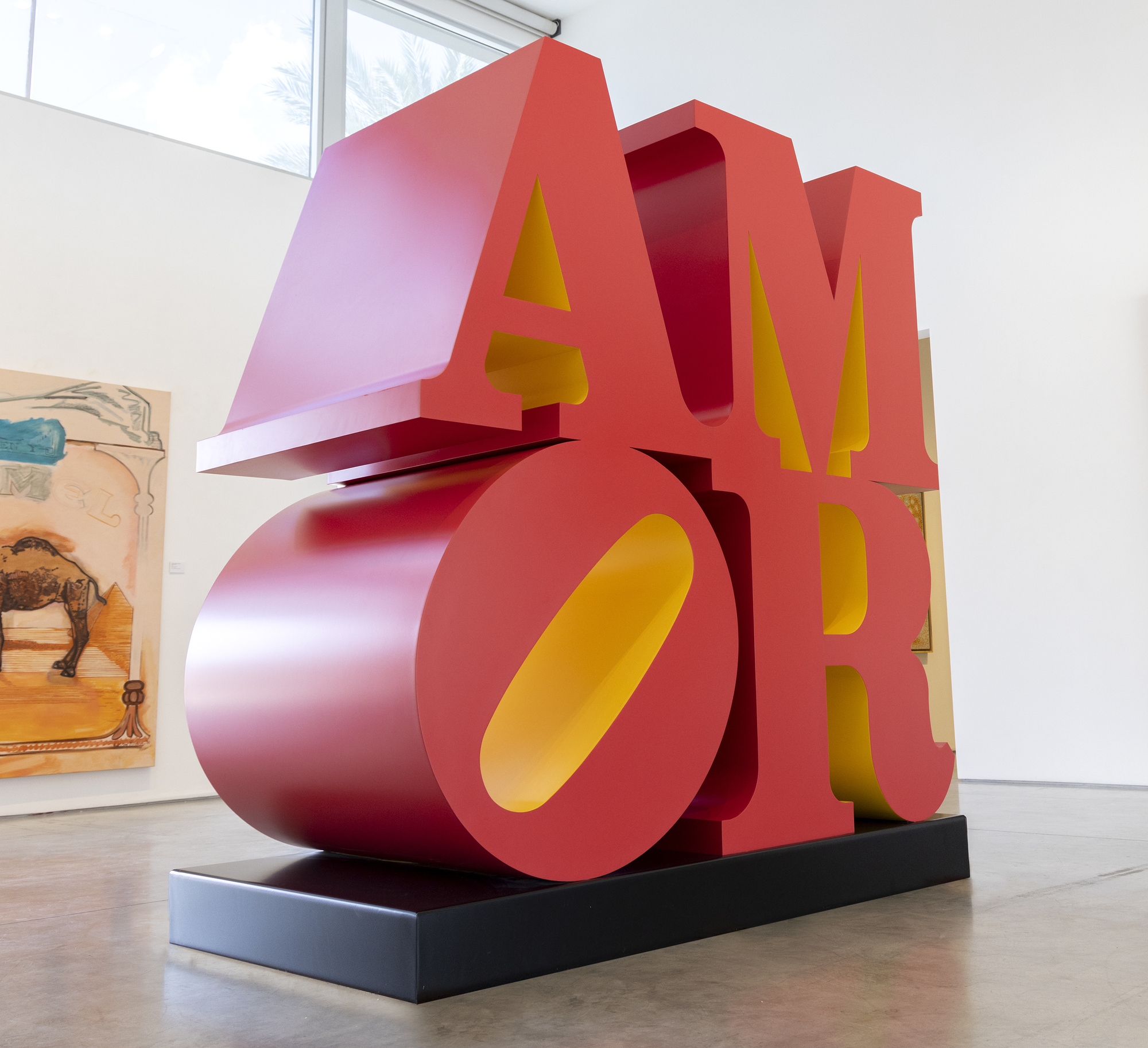ROBERT INDIANA - AMOR (Red Yellow) לא קשה להבין כיצד הסידור המבריק בן שתי השורות של רוברט אינדיאנה בן ארבע האותיות סייע להעצים תנועה בשנות השישים. מקורו בחשיפה עמוקה לדת ומהחבר והמנטור אלסוורת' קלי, שסגנונו הקשוח וצבעו החושני וחסר המבטא הותירו רושם עז. אבל כמו שאינדיאנה קרא, זה היה רגע של נשיקה שקרה בדיוק כש"אהבה נשכה אותי!" והעיצוב הגיע אליו חד וממוקד. אינדיאנה, כמובן, העבירה את העיצוב בצעדים רבים, ואז הלוגו החל לנבוט בכל מקום. המסר, המועבר בצורה הטובה ביותר בפיסול, עומד בערים ברחבי העולם ותורגם למספר שפות, שאחת מהן היא האיטרציה האיטלקית שלו, "אמור" עם האות "O" המקרית שלו גם היא מוטה ימינה. אבל במקום להיבעט ברגל של "L", גרסה זו מעניקה אפקט מתנודד מבוים להפליא ל "A" לעיל. זה נותן רושם חדש, אבל לא פחות עמוק, של אהבה וטבעה הטעון רגשית. בכל מקרה, האות O המוטה של לאב מקנה חוסר יציבות לעיצוב יציב אחרת, השלכה עמוקה של הביקורת המובלעת של אינדיאנה על "הסנטימנטליות החלולה לעתים קרובות הקשורה במילה, המרמזת באופן מטאפורי על כמיהה נכזבת ואכזבה במקום על חיבה סכרינית" (Robert Indiana's Best: A Mini Retrospective, New York Times, May 24, 2018). לחזרתיות, כמובן, יש הרגל מגונה להחליש את הערכתנו לגאונות של פשטות ועיצוב פורץ דרך. בשלב מאוחר בחייה, אינדיאנה קוננה על כך ש"זה היה רעיון נפלא, אבל גם טעות איומה. זה הפך פופולרי מדי. ויש אנשים שלא אוהבים פופולריות". אבל אנחנו, תושבי עולם רווי מחלוקות ולכודים במהומה, תודה. "אהבה" וגרסאותיה הרבות הן תזכורות חזקות ליכולתנו לאהוב, וזוהי תקוותנו הנצחית הטובה ביותר לעתיד טוב יותר.