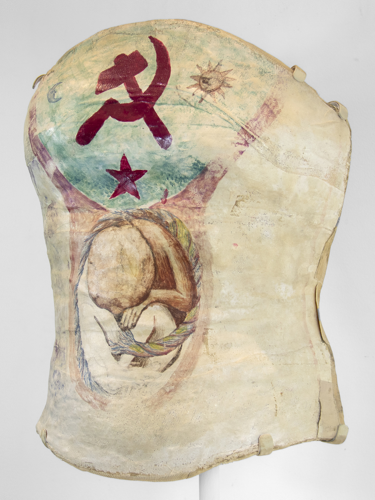 FRIDA KAHLO - Hammer and Sickle (and unborn baby) When Frida Kahlo died in 1954, a grief-stricken Diego Rivera had her belongings locked away for fifteen years, and her personal effects remained sealed, undisturbed, and undocumented until 2004 when the small room in the home her father built in Coyoacán, Mexico was opened to the world. Among the many belongings revealed at Casa Azul were her clothes, jewelry, drawings, letters, documents, and more than 6,500 photographs (among them works by Edward Weston, Tina Modotti, Man Ray, and Nickolas Muray) as well as the most personal and ironically moving item: the orthopedic plaster corsets she turned into an extension of herself. These harsh clinical objects assaulted her free-spirited nature, yet they remain today as the most palpable reminders that as she suffered through unbearable pain — over thirty surgeries, batteries of tests, X-rays, spinal taps, blood transfusions, physical therapy and strong pain killing drugs, she was an absolute survivor, not a victim.
<br>
<br>It was Frida’s father, Guillermo who gave her his box of paints and brushes as she was recovering from the bus accident that had shattered her spine. The devastation she suffered is shown in excruciating detail in her 1944 painting, The Broken Column. Yet the first canvas she painted upon was the most convenient one — the plaster cast bodice encasing her body. As she related, she had dreamed of becoming a doctor, yet “to combat the boredom and pain (and) without giving it any particular thought, I started painting.” Later, her mother asked a carpenter to fashion an easel “if that’s what you can call the special apparatus which could be fixed to my bed because the plaster cast didn’t allow me to sit up.” (Andrea Kettenmann, Frida Kahol: 1907-1954: Pain and Passion, Taschen, 1999, pg. 18)
<br>
<br>On this particular corset, Kahlo painted a blood-red Hammer and Sickle, the symbolic configuration representing proletarian solidarity — a union between the peasantry and working-class expressing her lifelong political sympathies and below, a developing fetus entering perhaps its third trimester, a reminder of the still deeper insult of the accident, the one that added a layer of suffering and regret to Frida’s personal tragedy — her inability to bear children. Frida’s corsets hardened around her resolve as much as her body, but they also speak of her almost unbearable longing. They are ruminations on the power of creativity to heal as well as demonstrations of Frida Kahlo’s unbounded capacity for confronting the very bodily enclosures that imprisoned her, transforming them, taking them over as much as she could, and turning them into something beautiful and expressive.
