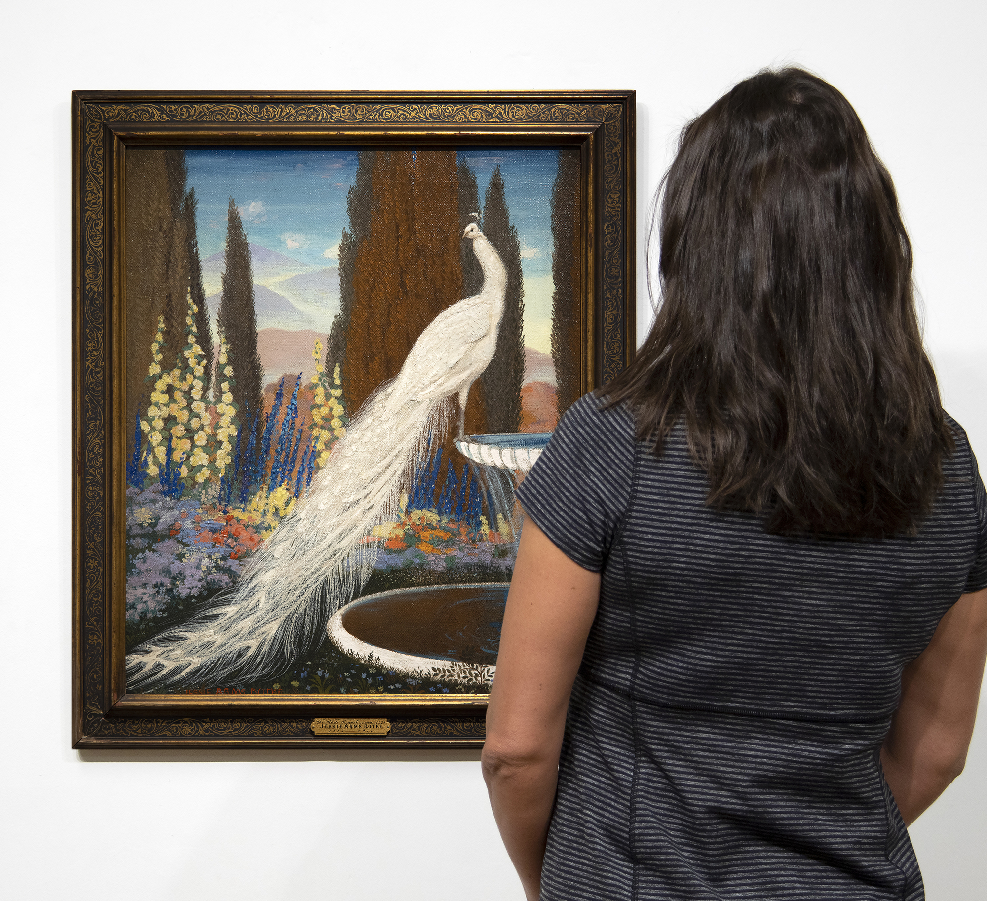 JESSIE ARMS BOTKE - The White Peacock The Arts and Crafts Movement in Great Britain and the corresponding ripples that made their way across the Atlantic Ocean were felt in the work of Jesse Arms Botke (1883-1971). Botke was born in Chicago, Illinois but found her home in California, where she had a successful career working first in Carmel and later in Southern California. <br><br>Rich textures, extensive use of gold leaf, and highly stylized birds would become synonymous with Botke's mature work as she established herself as one of the West Coast’s leading decorative mural painters of the 20th century.<br><br>"The White Peacock" (1922) shows an idyllic landscape with Botke's signature bird subject matter; the white peacock and cockatoos were among her favorite aviary subjects. Her work today can be found in countless museum collections, including the Art Institute, Chicago.