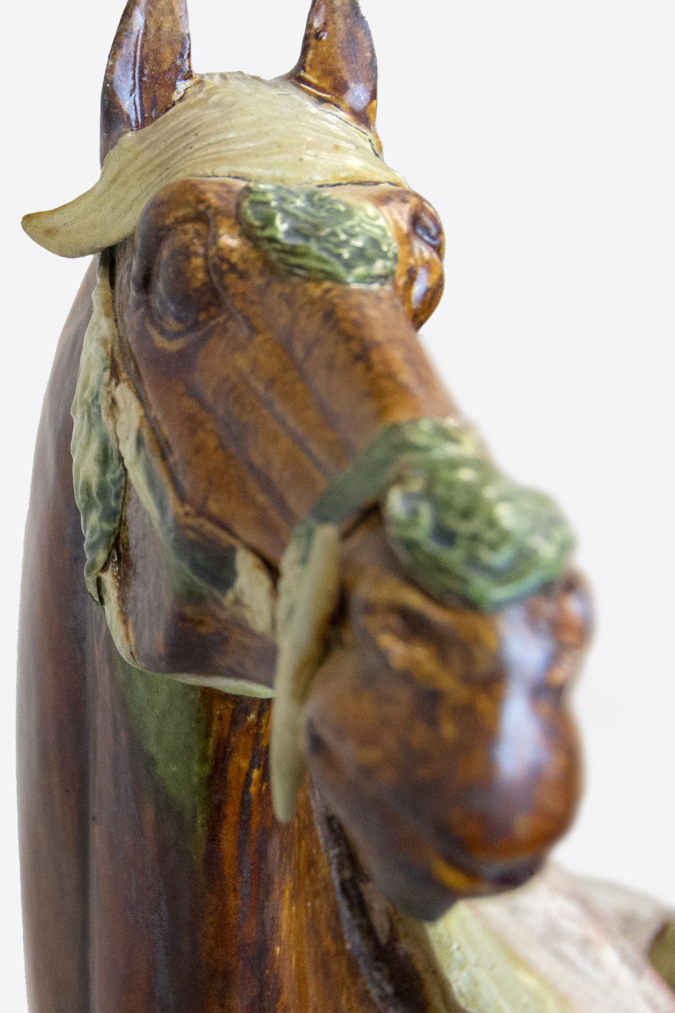 CHINESE - Sancai-Glazed Horse The Tang Dynasty (618-907 AD) was a prosperous period that helped shape Chinese history's foundations for future centuries. This era was marked by notable technological and cultural advances, including gunpowder and printing. Among artistic advances during this period was the perfection of the sancai glaze technique, which was a prominent attribute of sculpture during this period. Sancai (tri-colored) glazing used the three glaze-colors were ochre or brown, green and clear. Glazed wares were much more costly to produce than other terracotta wares, and were therefore only reserved for the wealthiest patrons. <br><br>This Sancai-Glazed Horse would have been an incredible status symbol for its owner and many have been lost to time. This sculpture is comparable to examples held in museum collections worldwide, including the Metropolitan Museum of Art, New York.