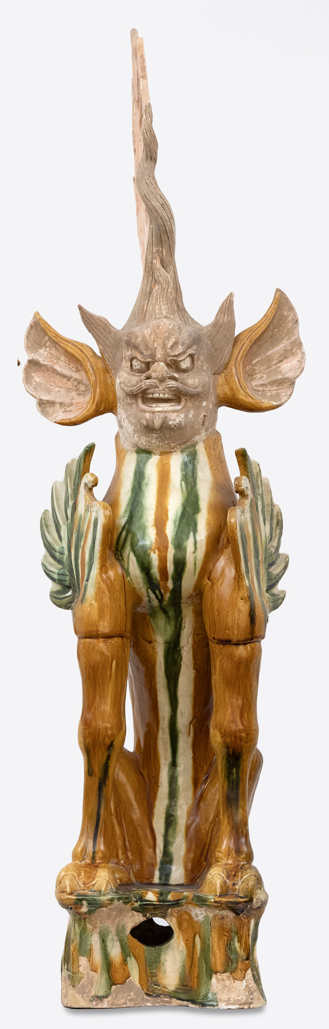 CHINESE - Sancai-Glazed Earth Spirit The Tang Dynasty (618-907 AD) was a prosperous cultural period that helped shape Chinese history's foundations for future centuries. This era was marked by notable technological and cultural advances, including gunpowder and printing. Among artistic advances during this period was the perfection of the sancai glaze technique, which was a prominent attribute of sculpture during this period. Sancai (tri-colored) glazing; the three glaze-colors used were ochre or brown, green and clear. Glazed wares where much more costly to produce than other terracotta wares, and were therefore only reserved for the wealthiest patrons.
<br>
<br>The Sancai-Glazed Earth Spirit offered here depicts a "Zhenmushou." These are mythical hybrid creatures whose bodies are a combination of dogs, lions, boars and other animals. These fierce looking beasts would be found in pairs guarding the entrance of Tang Dynasty tombs.