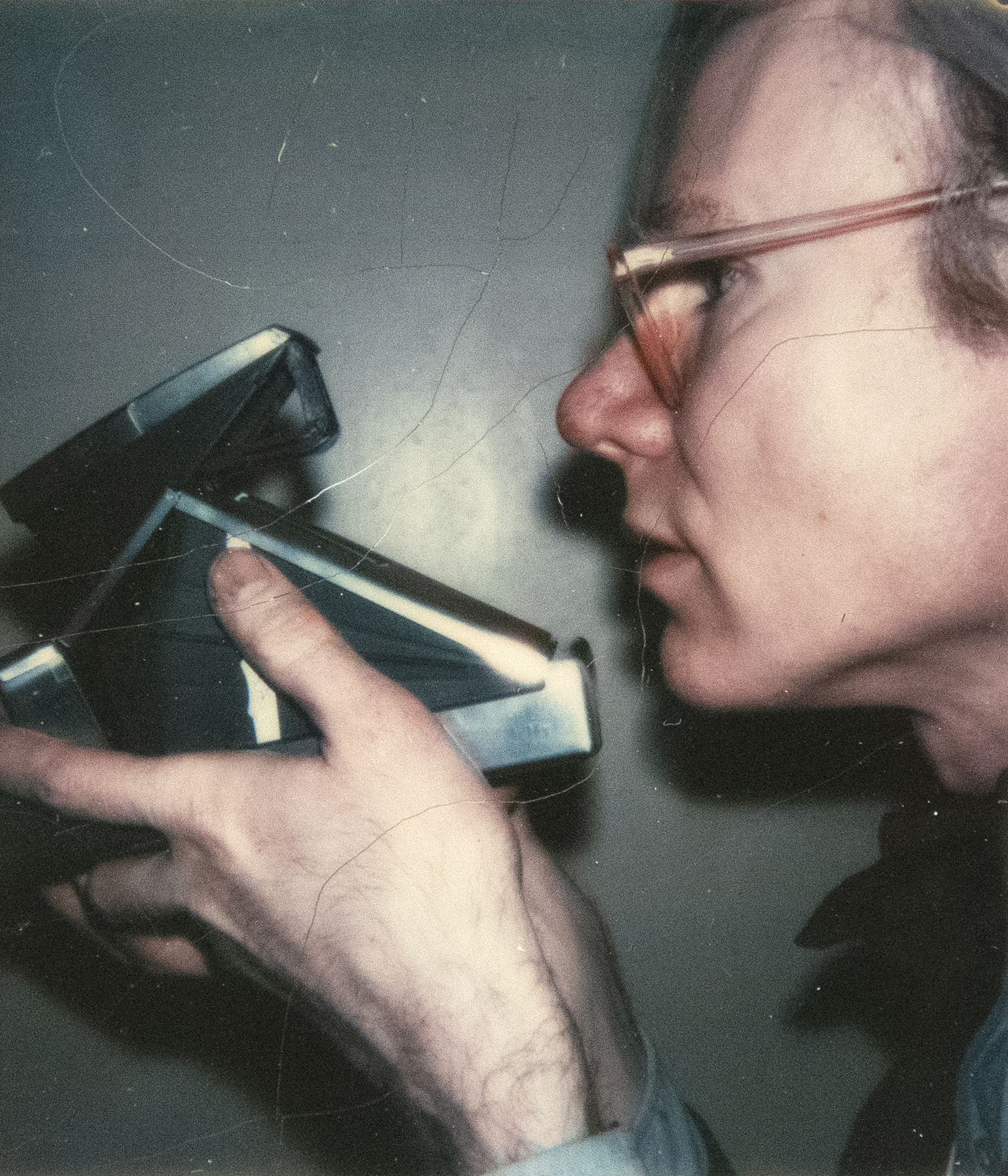 Andy Warhol carried a Polaroid camera as a relentless chronicler of life and its encounters from the late 1950s until he died in 1987. The vast collection of Polaroids he amassed are spontaneous, unpolished, often raw, and serve as a chronicle of his time, similar to how Instagram reflects our current era. Another person could have taken this self-portrait, creating a thinly veiled proposition asking the viewer to accept it as a self-portrait, or perhaps it was achieved solely by Warhol using an external self-timer accessory. It is a portrait that celebrates the device upon which Warhol's life essentially turned, a carefully staged homage to his relationship with the Polaroid camera.