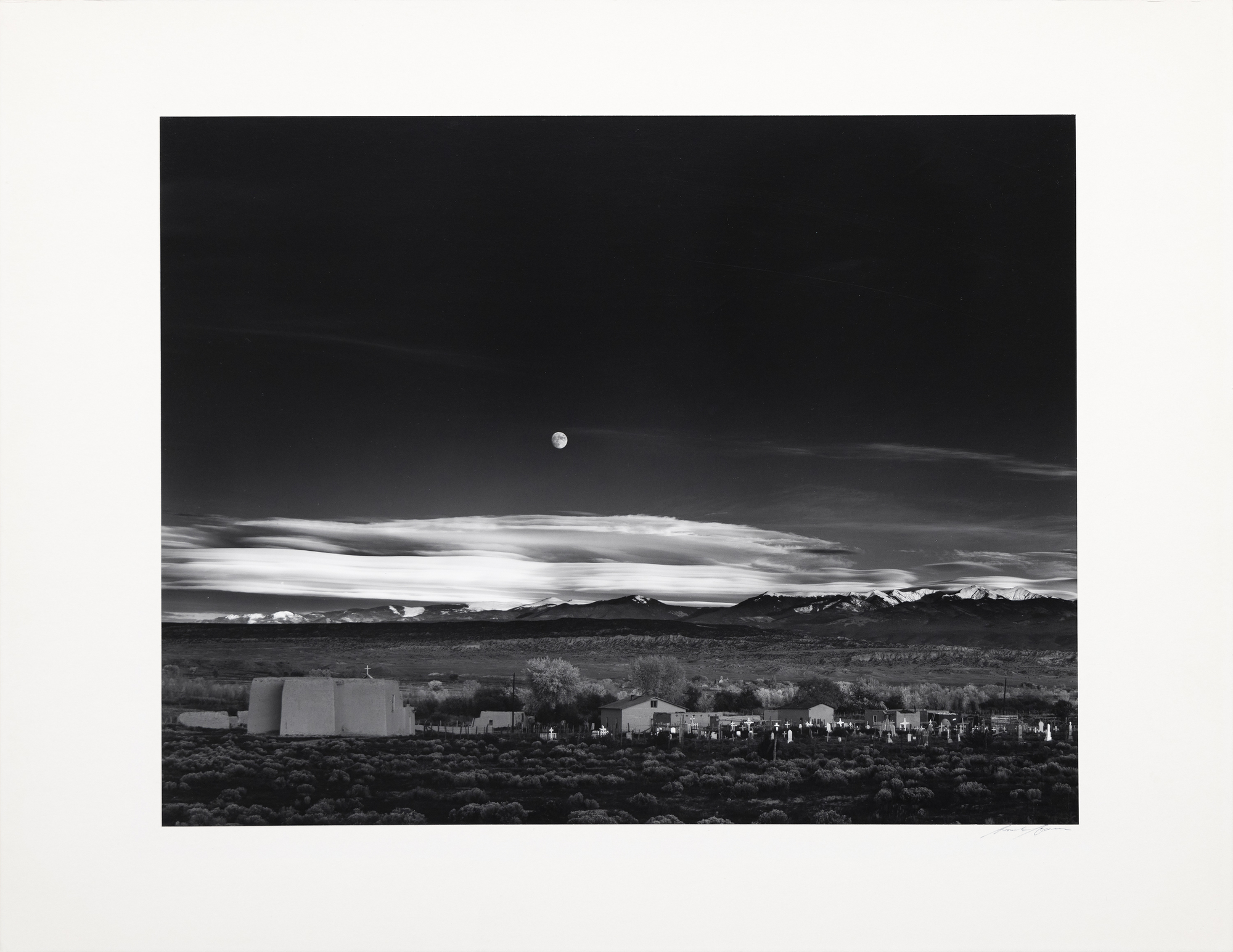 Known for his rigorous engagement in the darkroom, Ansel Adams created 1,300 prints of Moonrise, Hernandez over 40 years of dodging and burning, creating a longitudinal group of masterworks. Moonrise is a formidable composition that holds us in suspended appreciation for its hauntingly beautiful impression. We do not need to know of Ansel's desperate scramble to set his tripod, find his meter to grasp that transience, or ponder the kismet of capturing that moment. In this 1959 print, all the glorious details are present: the almost, but not quite, full moon with its discernable features and the essential graveyard with its glowing markers and starkly illuminated white crosses caught in the waning moment of daylight's inevitable retreat.