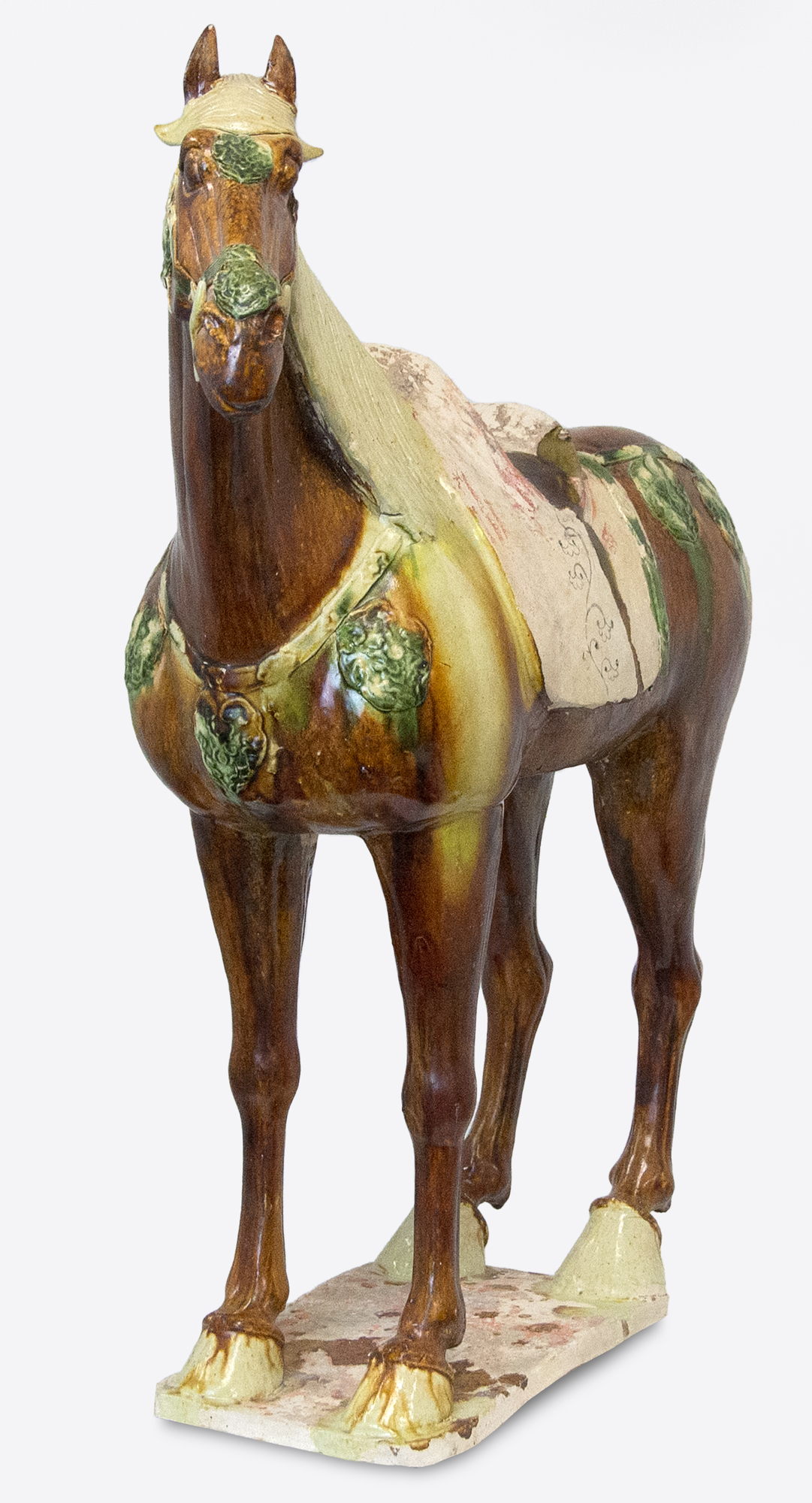 The Tang Dynasty (618-907 AD) was a prosperous period that helped shape Chinese history's foundations for future centuries. This era was marked by notable technological and cultural advances, including gunpowder and printing. Among artistic advances during this period was the perfection of the sancai glaze technique, which was a prominent attribute of sculpture during this period. Sancai (tri-colored) glazing used the three glaze-colors were ochre or brown, green and clear. Glazed wares were much more costly to produce than other terracotta wares, and were therefore only reserved for the wealthiest patrons.  
<br>
<br>This Sancai-Glazed Horse would have been an incredible status symbol for its owner and many have been lost to time. This sculpture is comparable to examples held in museum collections worldwide, including the Metropolitan Museum of Art, New York.