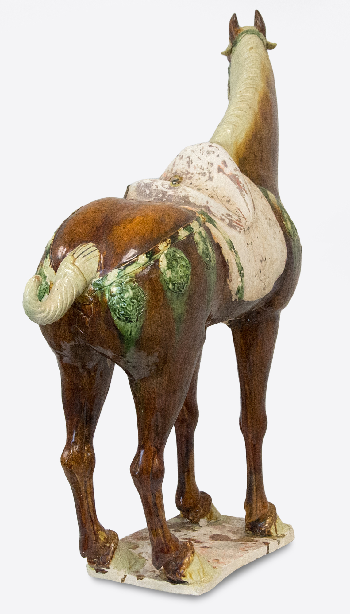 The Tang Dynasty (618-907 AD) was a prosperous period that helped shape Chinese history's foundations for future centuries. This era was marked by notable technological and cultural advances, including gunpowder and printing. Among artistic advances during this period was the perfection of the sancai glaze technique, which was a prominent attribute of sculpture during this period. Sancai (tri-colored) glazing used the three glaze-colors were ochre or brown, green and clear. Glazed wares were much more costly to produce than other terracotta wares, and were therefore only reserved for the wealthiest patrons.  
<br>
<br>This Sancai-Glazed Horse would have been an incredible status symbol for its owner and many have been lost to time. This sculpture is comparable to examples held in museum collections worldwide, including the Metropolitan Museum of Art, New York.