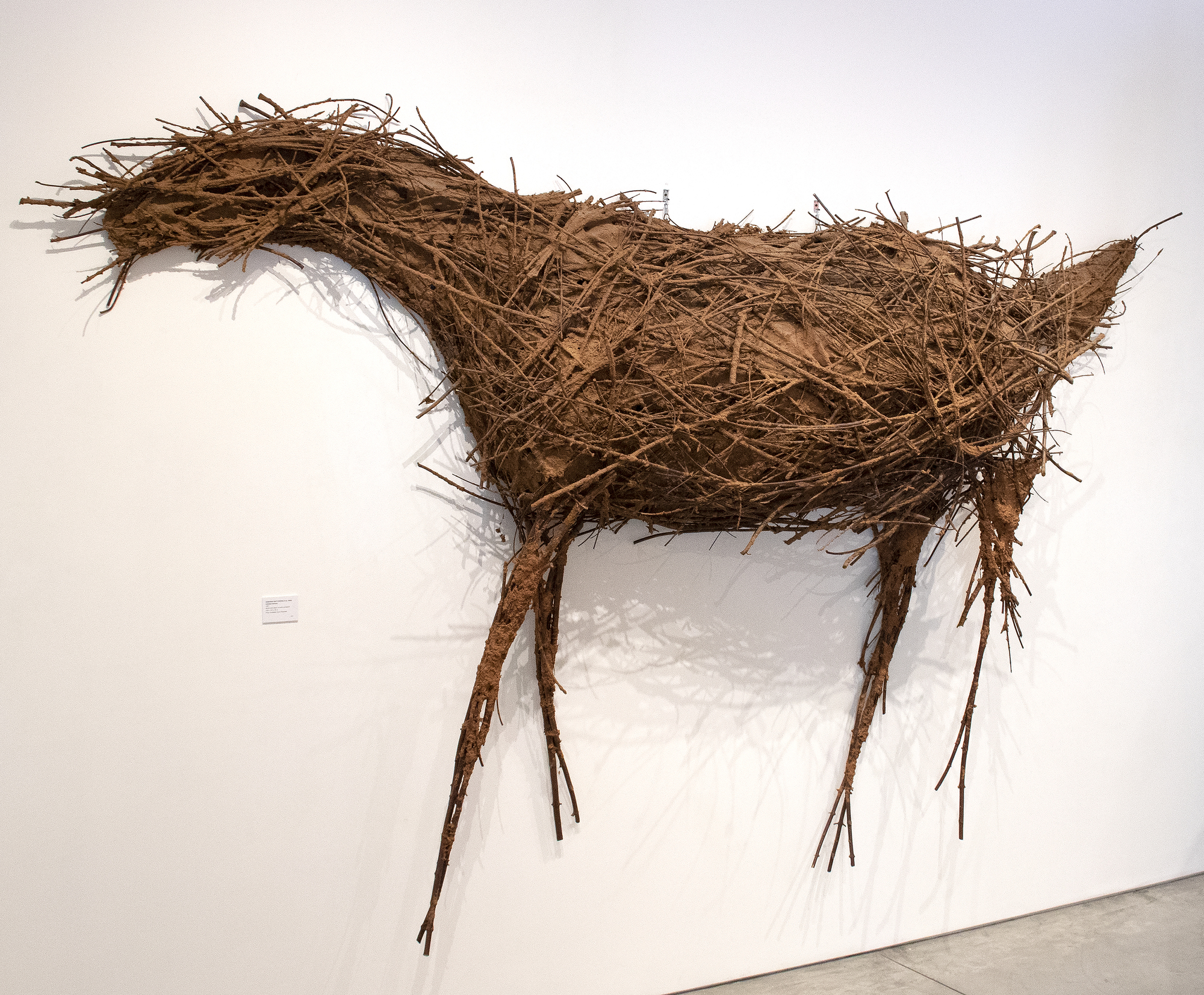 Deborah Butterfield est une sculptrice américaine, surtout connue pour ses sculptures de chevaux faites d&#039;objets en bois, en métal et autres objets trouvés. La pièce de 1981, Untitled (Cheval), est composée de bâtons et de papier sur armature métallique. L&#039;échelle impressionnante de cette pièce crée un effet remarquable en personne, présentant un exemple frappant du célèbre sujet de Butterfield. À l&#039;origine, Butterfield a créé les chevaux à partir du bois et d&#039;autres matériaux trouvés sur sa propriété à Bozeman, au Montana, et a vu les chevaux comme un autoportrait métaphorique, exploitant la résonance émotionnelle de ces formes.