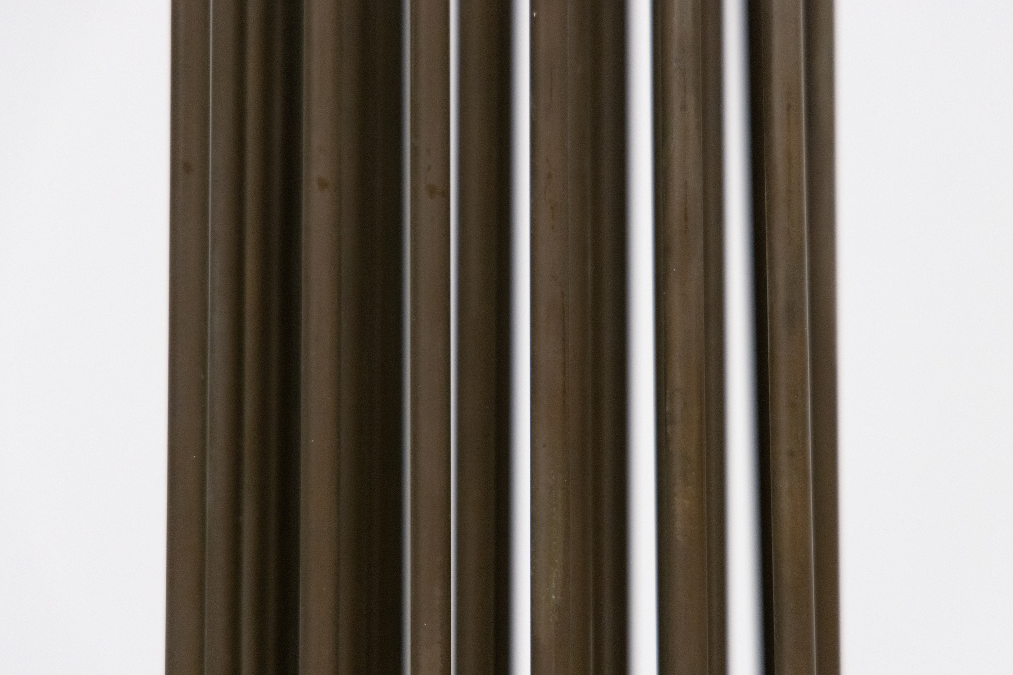<div><font face=Calibri size=3 color=black>Standing at an impressive 103 inches, this elegantly spare “Sonambient” sculpture by Harry Bertoia allows us to marvel at one of the finest artisans of his generation. This piece, the tallest in the series currently available here at Heather James Fine Art, features a precise arrangement of 36 slender tines in a 6 x 6 grid. This arrangement's uniformity and symmetry are visually captivating and crucial for the sculpture's acoustic properties. The rods, austere and uncapped by finials, have an aged patina with copper undertones, suggesting Bertoia's use of copper or a similar alloy known for its resonant qualities and distinctive coloration. Given the outstanding length of these rods, the attachment method is particularly noteworthy. Bertoia meticulously inserted each rod into individual holes in the base plate using precision drilling and securing techniques such as welding that ensured the rods were firmly anchored and stable, maintaining the structural integrity essential for consistent acoustic performance.</font></div>
<br>
<br><div> </div>
<br>
<br><div><font face=Calibri size=3 color=black>Beyond his uncompromising nature, Bertoia's work draws significant inspiration from natural elements. This sculpture's tall, slender rods evoke images of reeds or tall grasses swaying gently in the wind. This dynamic interaction between the sculpture and its environment mirrors the movement of plants, creating an immersive, naturalistic experience. Yet when activated or moved by air currents, the rods of this monumental work initiate metallic undertones that confirm its materiality without betraying its profound connection to the natural world.</font></div>
<br>
<br><div><font face=Calibri size=3 color=black>Integrating technical precision and natural inspiration depends on exacting construction that ensures durability and acoustic consistency, while its kinetic and auditory nature imbues the piece with a sense of vitality. This fusion invites viewers to engage with the sculpture on multiple sensory levels, appreciating its robust craftsmanship and evocative, naturalistic qualities. Bertoia's ability to blend these elements results in a work that is both a technical marvel and a tribute to the beauty of the natural world.</font></div>
