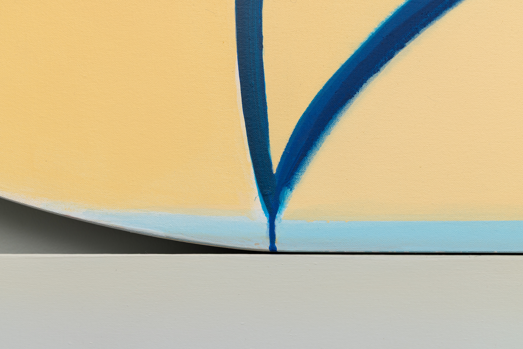 <div>Joanna Pousette-Dart’s 3 Part Variation No. 11 (2017) is composed of three stacked, curvilinear canvases—forms that resemble canoe hulls or slices of a circle—rising in scale from bottom to top. Each panel has its own restrained palette of blues, yellows, and grays, distinct yet resonant with the others. The proportions and curves echo from one to the next, yet no two forms are alike. </div>
<br>
<br><div> </div>
<br>
<br><div>Within each panel, broad areas of flat color are bisected by rounded shapes whose outer contours align with the painting’s edge. Layered over these are linear arabesque-like structures that visually rhyme—but never directly repeat—the panels’ curves, creating a dynamic interplay between inner drawing and outer shape. The result is both lyrical and precise, a composition where subtle variations generate a complex harmony. </div>
<br>
<br><div> </div>
<br>
<br><div>The beauty of 3 Part Variation No. 11 lies in these relationships: how forms mirror, diverge, and converge across the three canvases. The effect is meditative, like a visual equation that is at once architectural and deeply personal. </div>