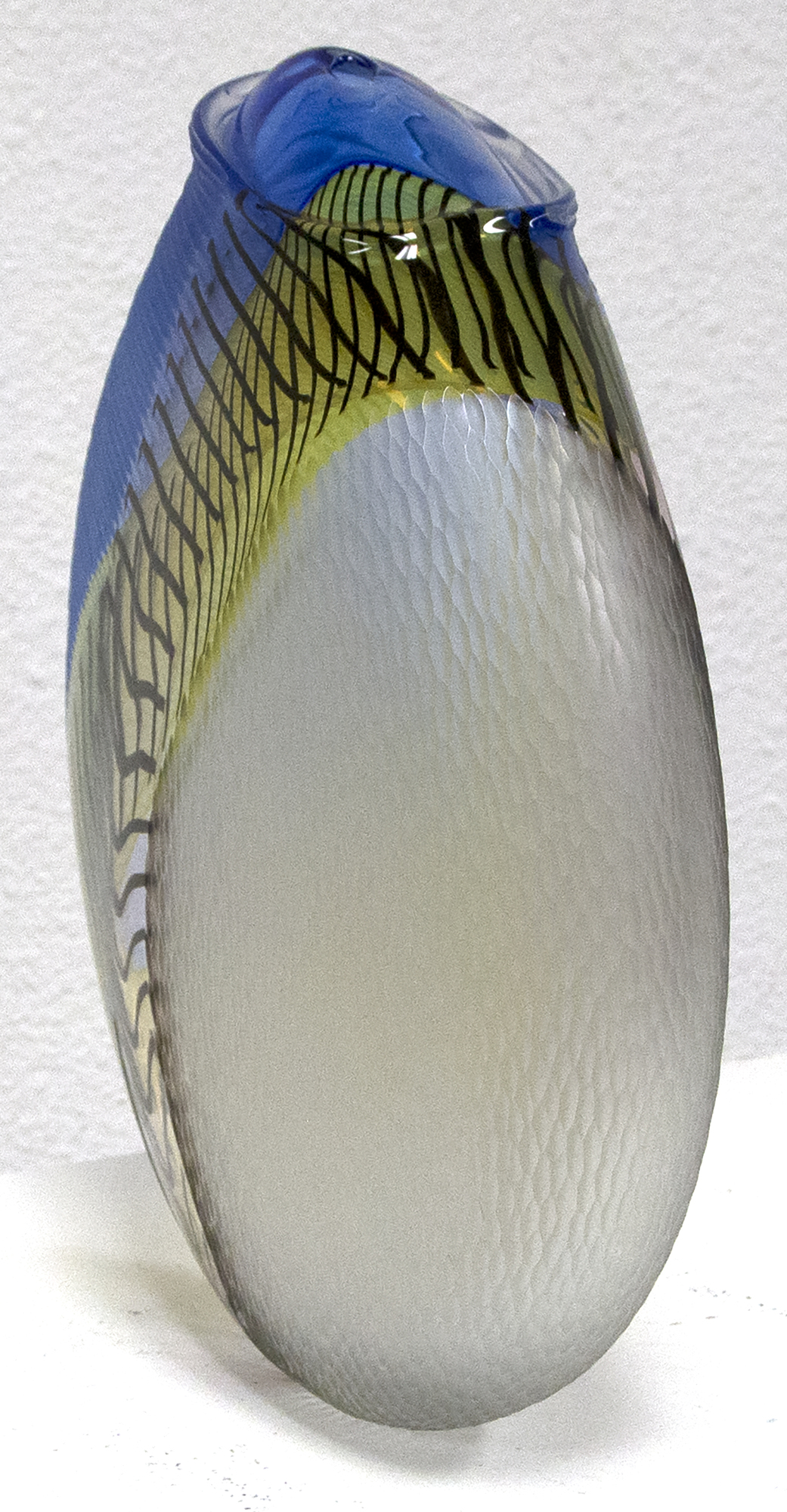 Hand blown glass with multiple incalmo of colored glass and filligrana. Switching the axel of the glass bubble and adjoining two glass bubbles with raticallo technique. Engraved partially on the surface with different patterns.
<br>
<br>Lino Tagliapietra, a native to Murano, is one of the world's preeminent glass artists.