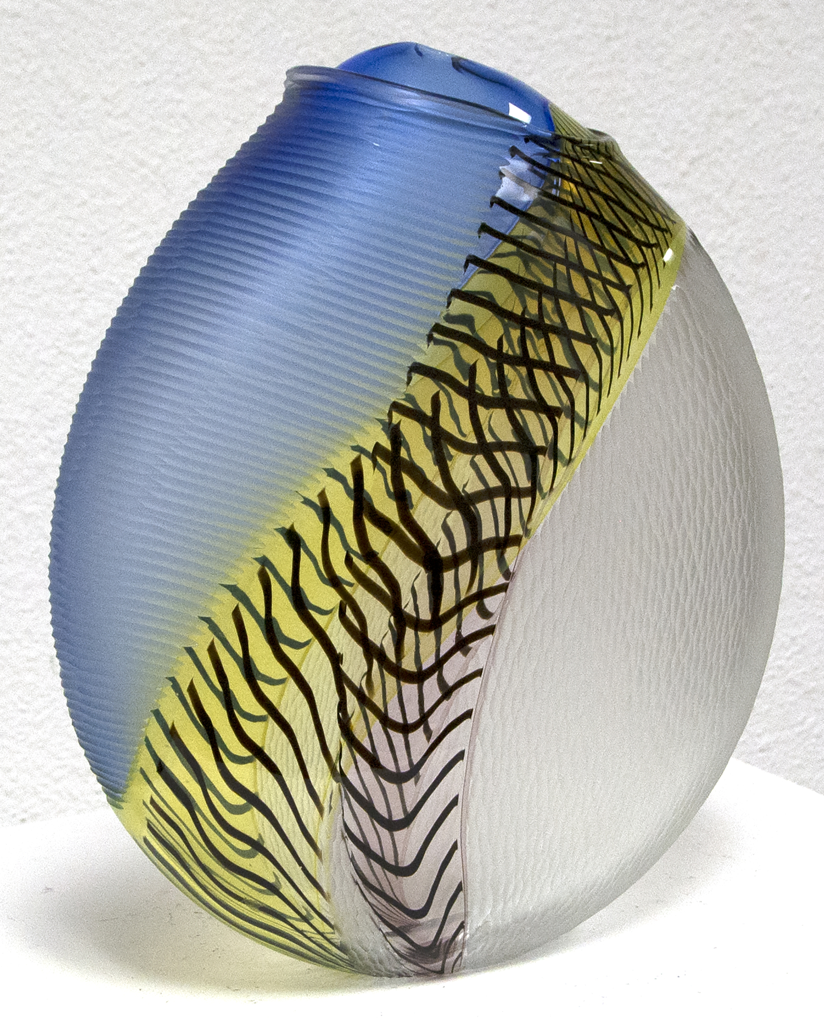 Hand blown glass with multiple incalmo of colored glass and filligrana. Switching the axel of the glass bubble and adjoining two glass bubbles with raticallo technique. Engraved partially on the surface with different patterns.
<br>
<br>Lino Tagliapietra, a native to Murano, is one of the world's preeminent glass artists.