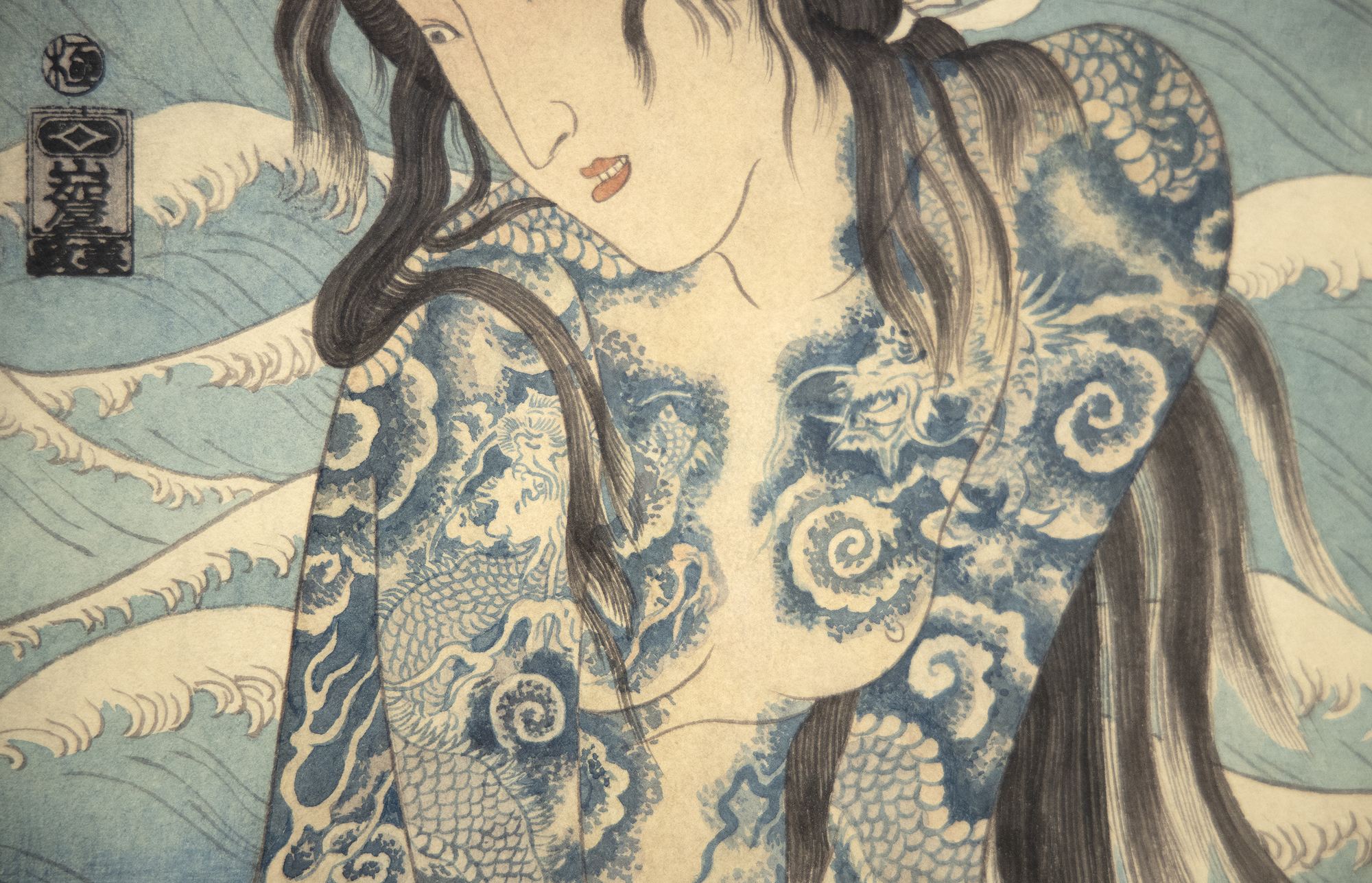 MASAMI TERAOKA - Wave Series/Tattooed Woman at Sunset Beach Born in Onomichi in Hiroshima Prefecture, Teraoka studied at what is now Otis College of Art and Design in Los Angeles. His works are inspired by Japanese Ukiyo-e woodcut prints. However, Teraoaka infuses the style and techniques of the traditional art with American Pop Art. The mass-produced nature of Japanese woodcut prints alligns with the obsession with mass production and consumption of Pop Art. Additionally, Ukiyo, meaning “the floating world” in Edo period Japan reflected the transitory nature of Kabuki theater and pleasure houses. This transitory sense of consumerism and pleasure was also evoked in the works by Pop Artists. Teraoka’s works are a collision of two cultures and histories of art finding affinities through similar themes.<br><br>Teraoka’s pieces blend humor and social commentary. He has often touched upon subjects as diverse and urgent as the AIDs crises, consumerism, the attacks on September 11th, and more. Teraoka notes of his own work, “Integrating reality with fantasy, humor with commentary, and history with the present became my challenge.”<br><br>Works by Teraoka can be found in the Tate Modern, the Metropolitan Museum of Art, the San Francisco Museum of Modern Art, the Smithsonian, the Los Angeles County Museum of Art, the Walker Art Center, and more.