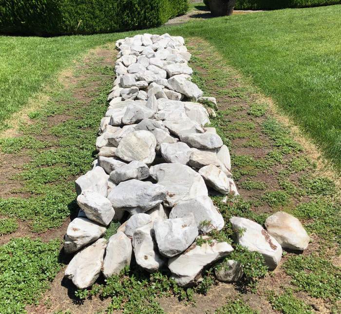 RICHARD LONG - Georgia Granite Line Among the best-known British land artists, Richard Long is the only artist to have been short-listed four times for the Turner Prize. He was a nominee in 1984, 1987, 1988, and won the prize in 1989 for White “Water Line.” Long has described his practice as "a balance between the patterns of nature and formalism of human, abstract ideas of lines and circles.” Going on to say, “It is where my human characteristics meet the natural forces and patterns of the world, and that is really the kind of subject of my work."
<br>
<br>The starting point for his sculpture is a walk over terrain. Since the mid-1960s, Long’s walking practice has taken him to the Sahara Desert, Australia, Iceland, and all around his home in Bristol, England. The memory of the event of a hike, a topographic feature for instance, is carried forward in his sculptures. Photography, text, and maps of the landscapes he has walked are also an important part of his practice, and sometimes he creates his sculptures within the landscape from rocks or other natural materials and photographs them. In “Georgia Granite Line,” Long uses the typical white granite of the U.S. state, which has been sought after since the early 19th century for its color.